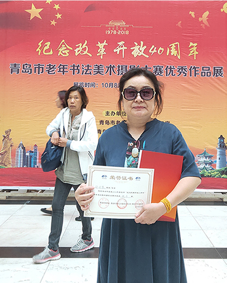 郑安荣参加青岛市老年书法美术摄影大赛优秀作品展《纪念改革开放四十周年》领奖照片.jpg