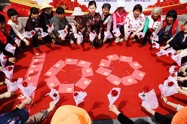 谢才保作品3-2021.5.（百年庆典）为了庆祝中国共产党建党100周年庆典，这些社区的妈妈奶奶们，手持红玫瑰花，将党旗组合成100字样，合影留念.jpg